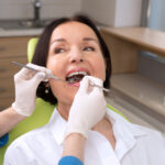 Brunette woman receives a cleaning at the dentist in Chandler, AZ