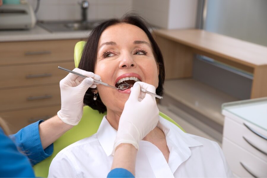 Brunette woman receives a cleaning at the dentist in Chandler, AZ