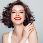 Brunette woman smiles with red lipstick